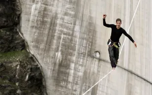 بالفيديو..مغامر يسجل رقماً قياسياً بالسير على حبل بارتفاع 650 قدماً