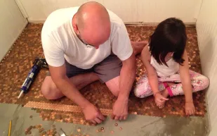 بالصور.. رجل يستبدل بلاط غرفة نومه بالنقود المعدنية! 