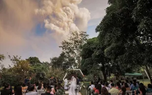 زفاف محفوف بالمخاطر.. عروسان يقيمان حفل زواجهما بالقرب من بركان تال الثائر «فيديو»