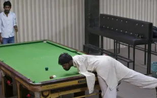 معتمدا على رأسه .. شاب بدون يدين يحقق انتصارات عالمية في البلياردو (فيديو)