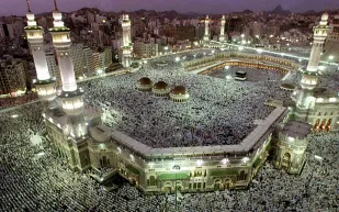 فرحًا بإلغاء الإجراءات الاحترازية سعودي يوزع أموالاً على عمال الحرم المكي