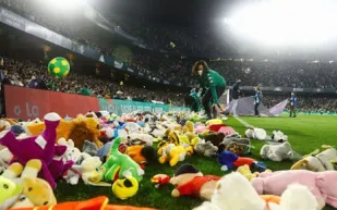 لماذا ألقى الجمهور آلافًا من دمى الأطفال داخل الملعب؟ (فيديو)