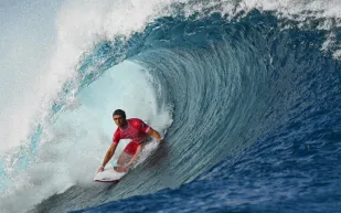 مشهد نادر يوثق تناغم راكب أمواج مع عشرات الدلافين البرية (فيديو)