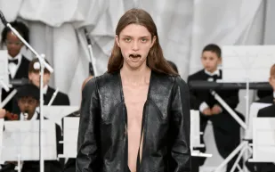 إطلالة غريبة في أسبوع الموضة.. أفواه العارضين مُقيدة بشعار غامض