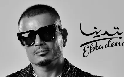 مجوهرات فاخرة وسترة مرصعة بكريستالات.. تفاصيل إطلالة عمرو دياب على بوستر الألبوم الجديد