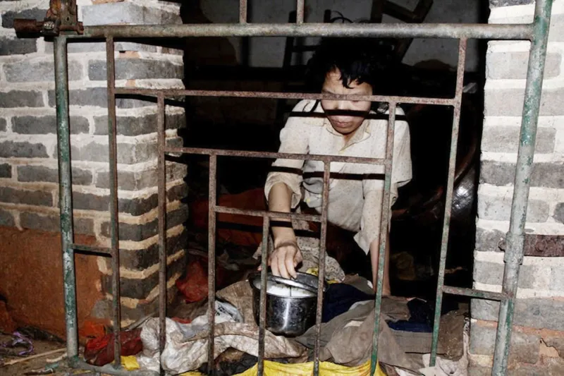 بالصور...صيني يشتري زوجته من سوق العبيد ويحبسها في قفص