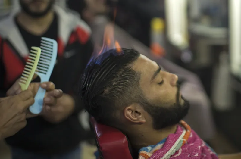 رمضان عدوان ..حلاق فلسطيني يحلق رؤوس زبائنه بالنار ! (صور)