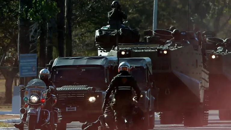 لصوص يسطون على بنك ويتخذون الرهائن دروعا بشرية أعلى السيارات ! (فيديو)