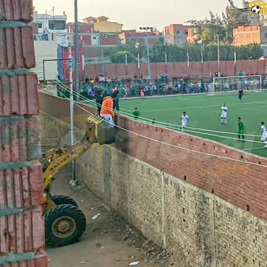 مدرب يقود فريقه في مباراة لكرة قدم من فوق جرافة (فيديو)