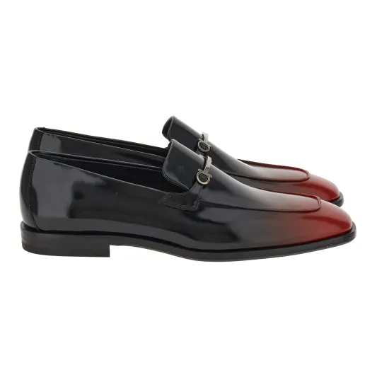 حذاء Loafer من Ferragamo مصنوع من جلد العجل الناعم اللاّمع يزيّنه إبزيم Gancini الرفيع المزدوج ويتميّز بطرفه الأماميّ الطويل وبلونه الذي يتدرّج من الأسود إلى الأحمر - المصدر: Ferragamo أحذية "Loafers".. لا مفرّ منها في هذا الموسم