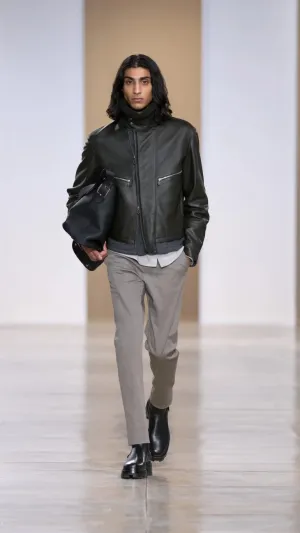 جاكيت قصير من الجلد الأسواد وبنطال رمادي اللون وشنطة سوداء كبيرة - المصدر: "Hermès" مجموعة "Hermès" لشتاء 2024.. طابع الفروسية يمنح الجرأة والقوة لكل قطعة