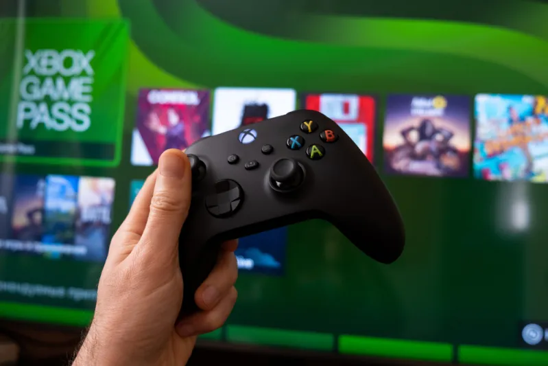 ذراع تحكم Xbox Series X على خلفية الجيم باس- مصدر الصورة: Shutterstock "Microsoft" تُفكر في بيع حصرياتها للمنافسين والتوقف عن إنتاج أجهزة "Xbox"