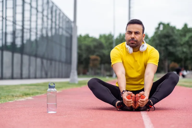 رجل يمارِس تمرين إطالة تعبيرية عن تمارين الاسترخاء لتخفيف التوتر وتحسين الأداء - المصدر: Shutterstock أفضل تمارين الاسترخاء لتخفيف التوتر وتحسين الأداء الرياضي