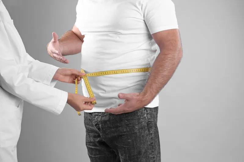 طبيب يقيس محيط الخصر لرجل تعبيرية عن الأضرار المحتملة لفقدان الوزن السريع - المصدر: Shutterstock هل يستحق فقدان الوزن السريع المخاطرة؟ إليك 4 أضرار محتملة