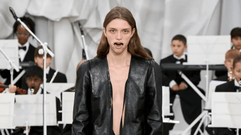 إطلالة غريبة في أسبوع الموضة.. أفواه العارضين مُقيدة بشعار غامض