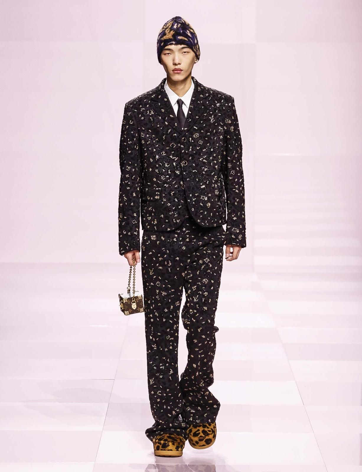 الجرأة على طريقة Louis Vuitton صاخبة تلامس روح الرجل، الذي يميل إلى التجدد في كل حين. وعلى هذا الوقع، يتألق الطقم العصري بقوة حضوره وبزخارفه بالغة التأثير وبسترته المبتكرة والمرهفة. أما الإكسسوارات فتضيف فيضًا من العذوبة تحاكي روح العصر من خلال قلنسوة دافئة وحقيبة هادئة