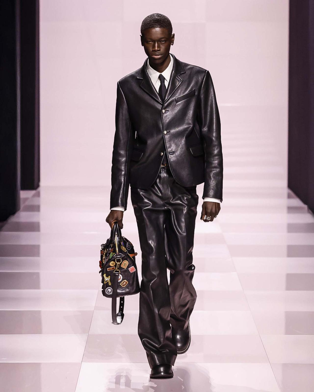 ليكن خيارك في المناسبات الرسميّة، اللون الأسود الحادّ رمز القوّة والهيبة. ووفق قواعد Louis Vuitton الإبداعيّة، يداعب الأسود ديناميكيّة هذا الطقم الفاخر، الذي يتماهى مع قميص أبيض ناصع وربطة عنق أنيقة وحقيبة عصريّة وخواتم جميلة