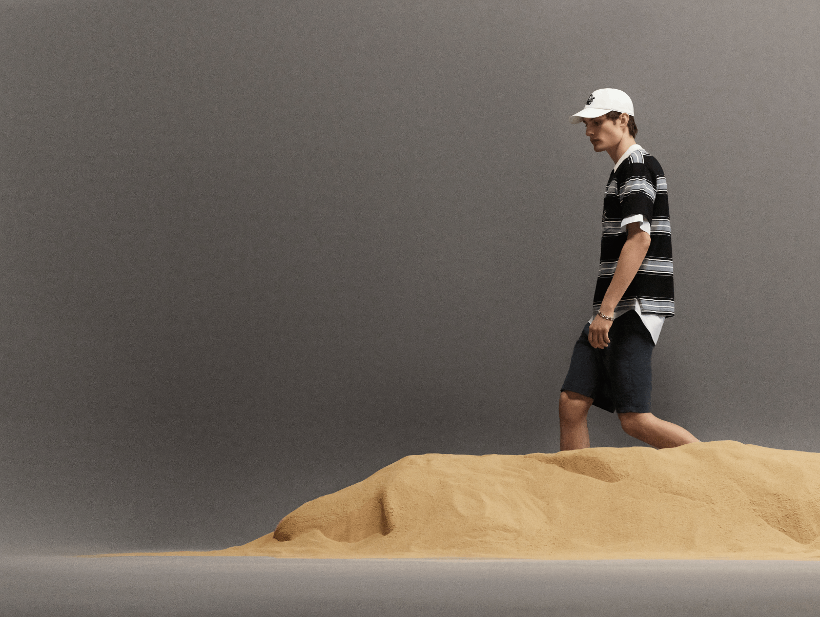 قبعة البيسبول البيضاء ضرورة في الصيف، فكيف إذا اكتملت على طريقة مجموعة Dior Essentials من Dior مع تيشرت مخطط أفقيًا مع سروال أحادي اللون