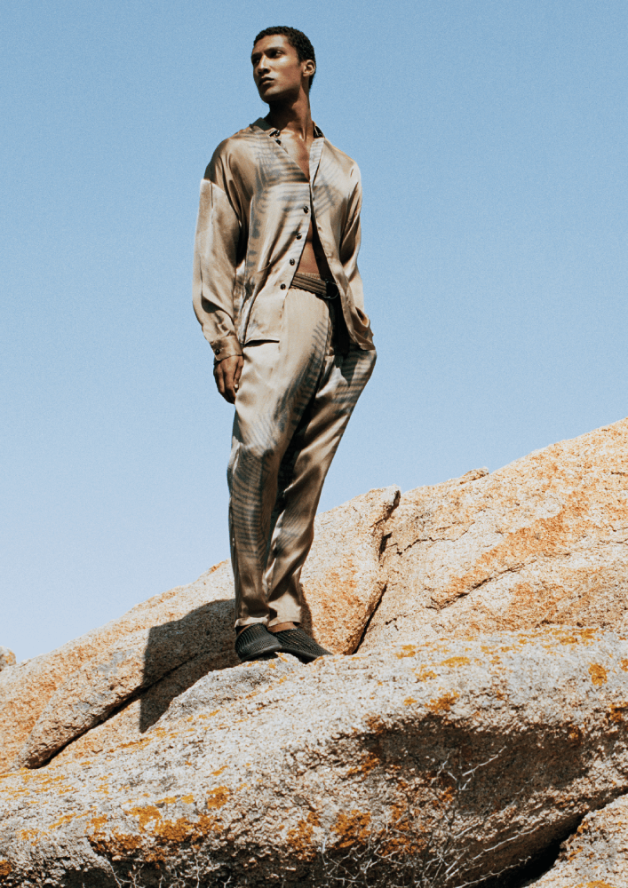 التحرر من الضوابط تكشفه هذه الإطلالة من مجموعة Giorgio Armani Mare من Giorgio Armani، وفيها يبرز قميص رائع مزود بأزرار يمكن فتحه وإغلاقه حسب الذوق والحاجة، وهو منفذ من القماش اللطيف الذي يعشقه الصيف، ومرفق بسروال مريح مطاطي عند الخصر. 