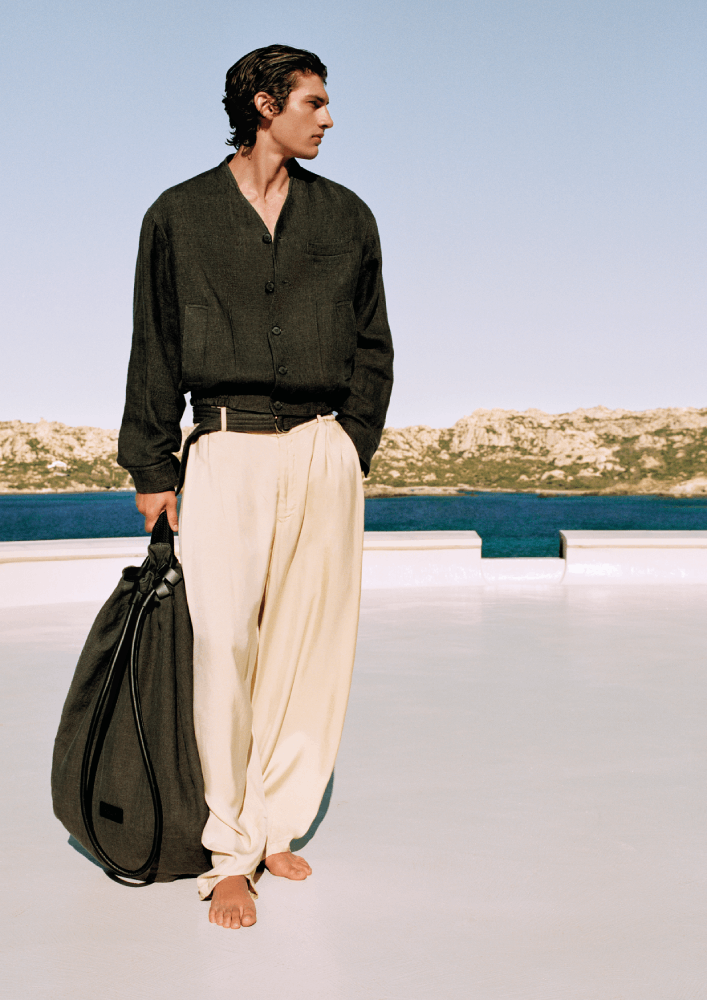 الأسود ملك في الصيف أيضًا، ويزداد سحرًا في دمجه مع سروال عصري من قائمة لون البيج الذي يتحايل على الحرارة الساخنة، من مجموعة Giorgio Armani Mare من Giorgio Armani