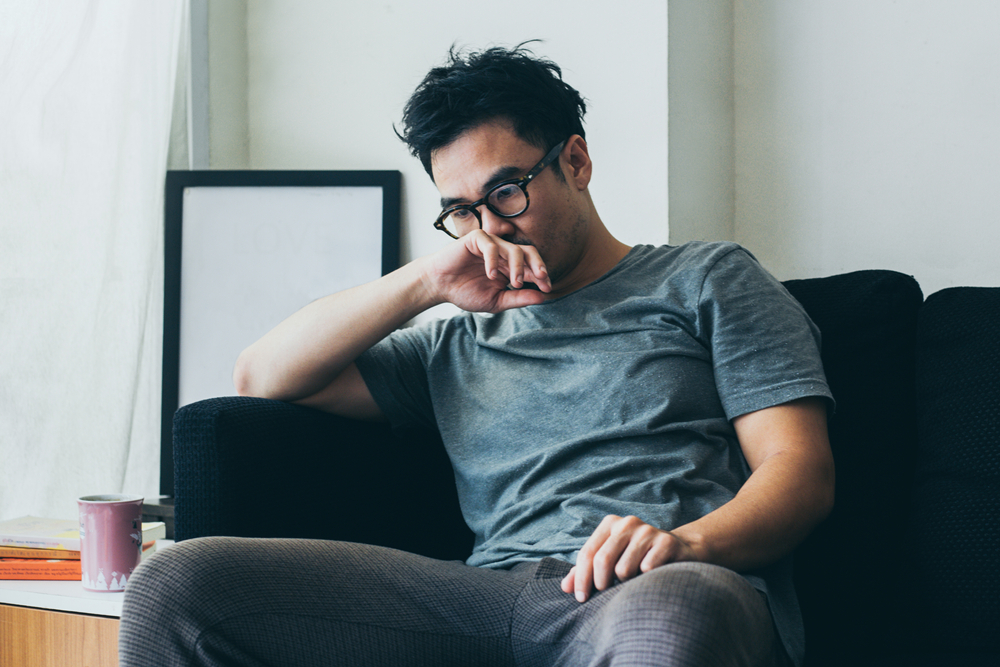 رجل متردد يفكّر مليًا تعبيرية عن صعوبة اتخاذ القرارات أحد العلامات الخفية للقلق اللاواعي