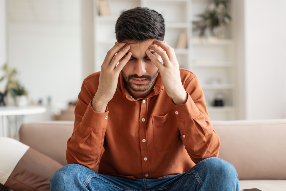 رجل يعانِي صداعًا تعبيرية عن العلامات الجسدية للقلق اللاواعي