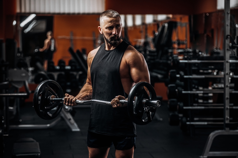رجل يحمل الأثقال تعبيرية عن تدريبات القوة لتحقيق أفضل النتائج مع رجيم اللحوم