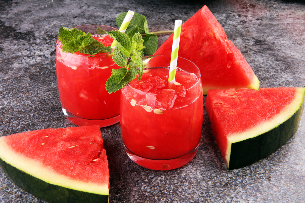 شرائح وعصير البطيخ تعبيرية عن أفضل الأطعمة لتعزيز الدورة الدموية الجنسية