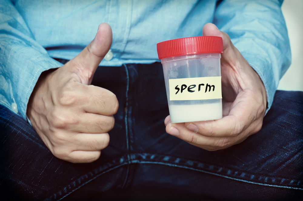 رجل يحمل عينة سائل منوي تعبيرية عن كيف تعمل اختبارات الخصوبة المنزلية للرجال؟