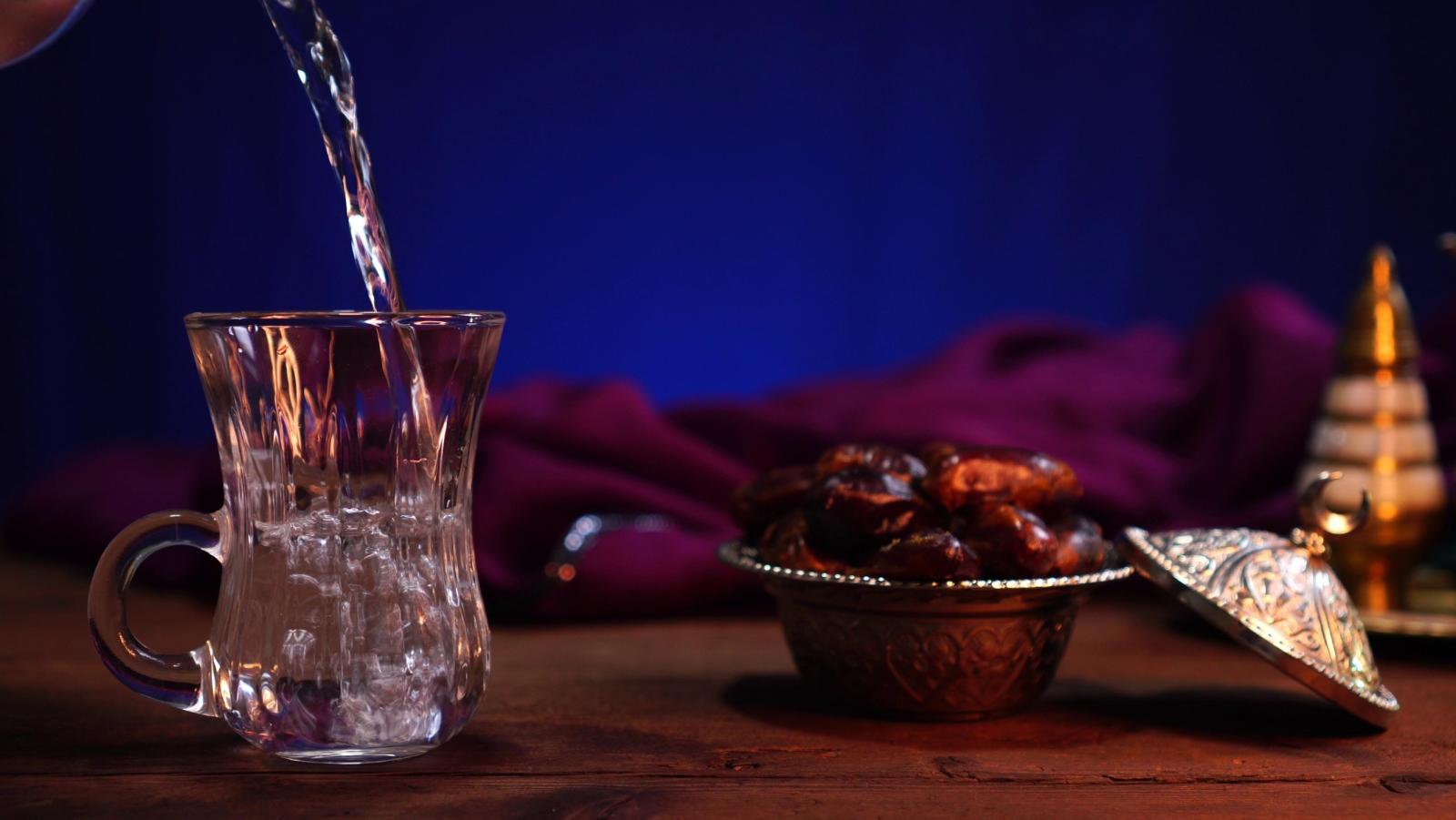 تمر وكوب ماء تعبيرية عن ممارسة التمارين الرياضية بعد الإفطار