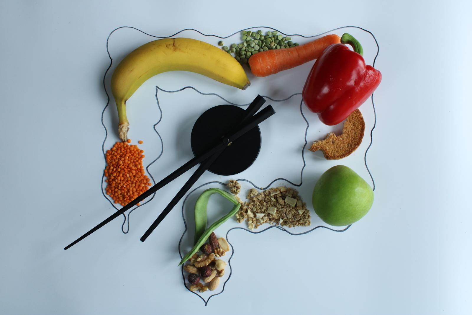 مجموعة أطعمة مع رسم للقولون تعبيرية عن النظام الغذائي قليل الفودماب لمرضى القولون في أثناء الصيام