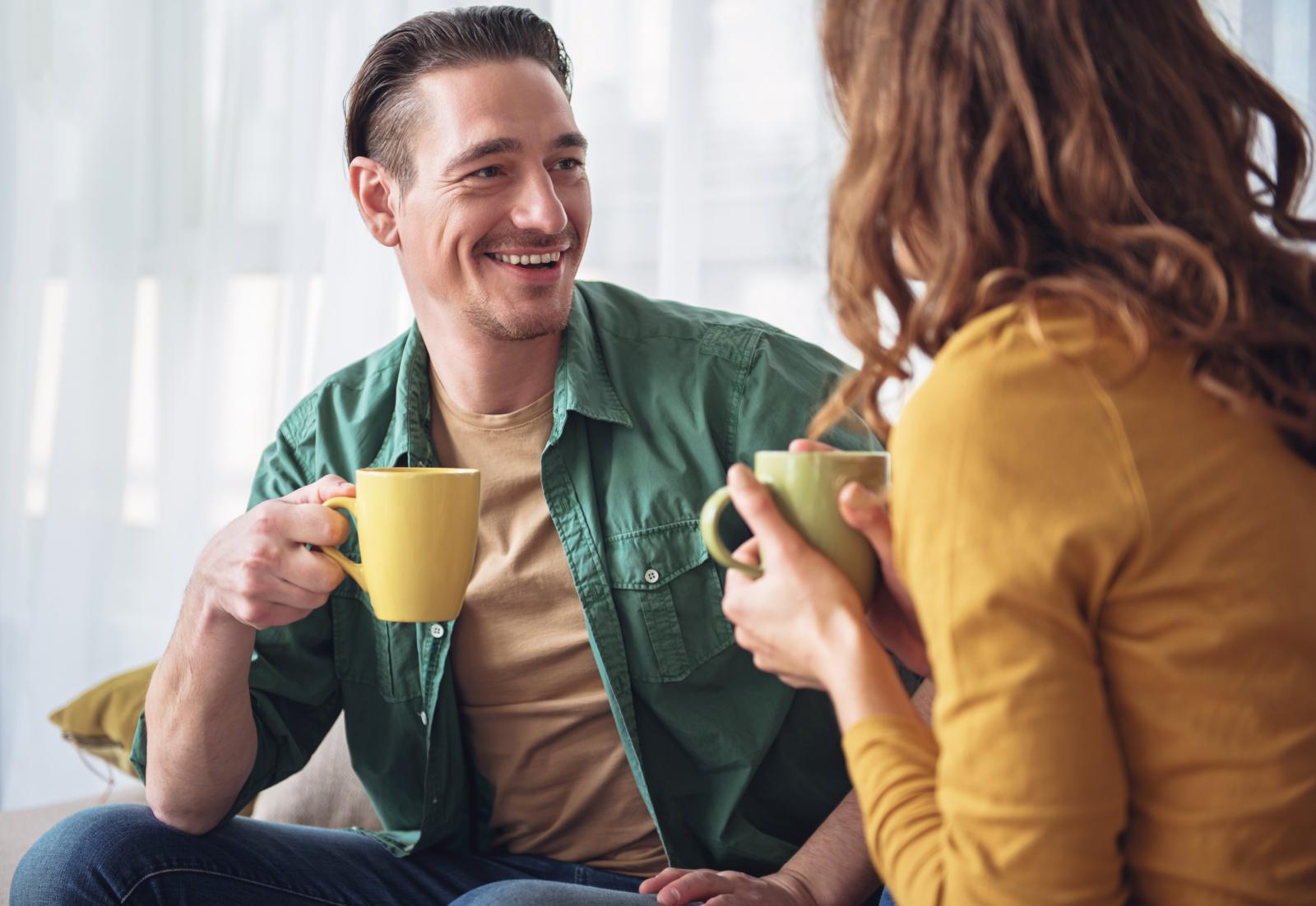 زوج مبتسم لزوجته تعبيرية عن تحسين التواصل للحفاظ على استقرار العلاقة