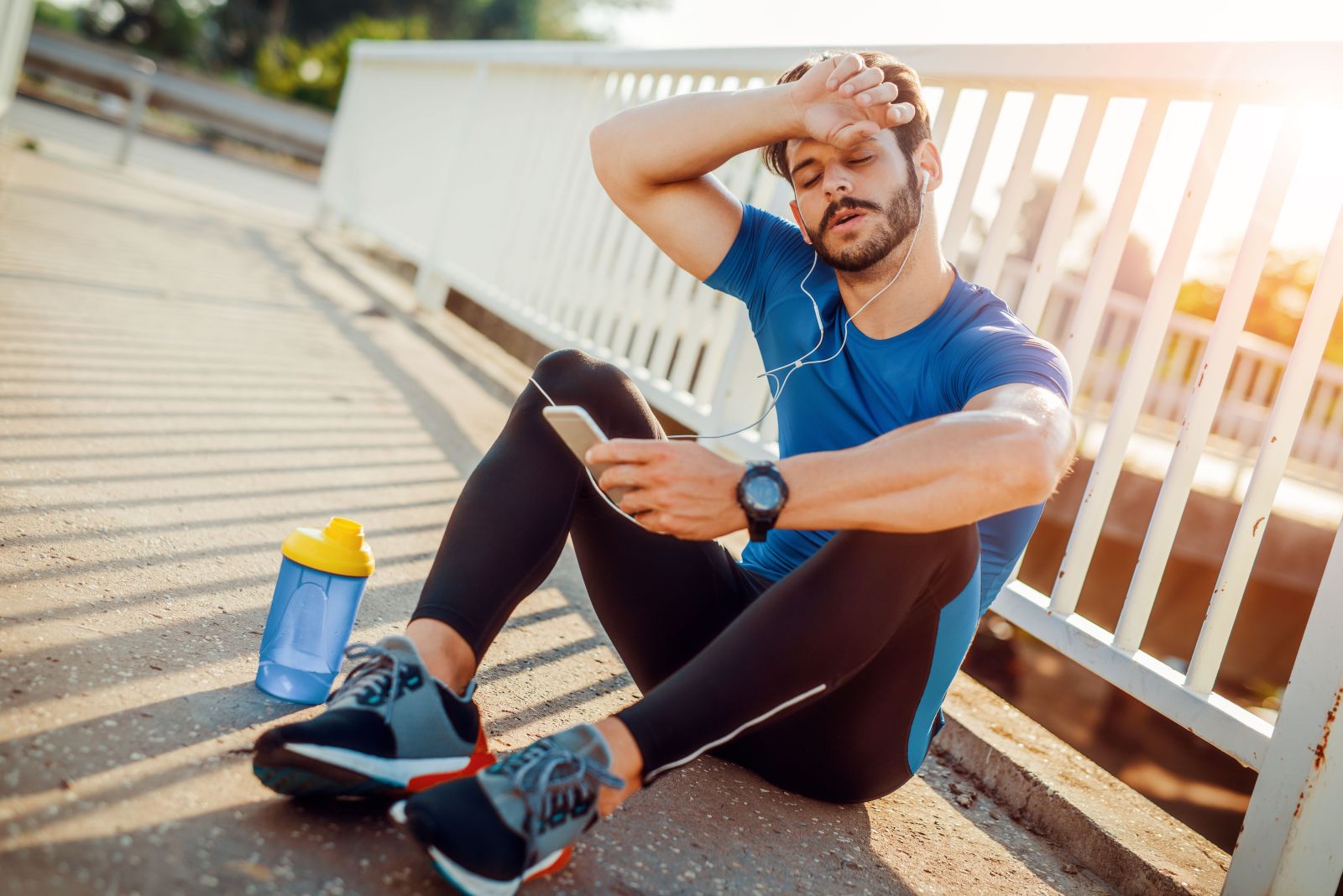 رجل يستريح بعد التمارين تعبيرية عن فترات الراحة لممارسة تمارين HIIT بأمان