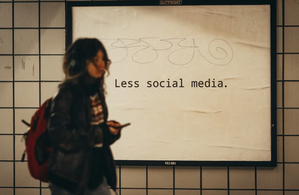 فتاة تمر أمام لافتة "سوشيال ميديا أقل"