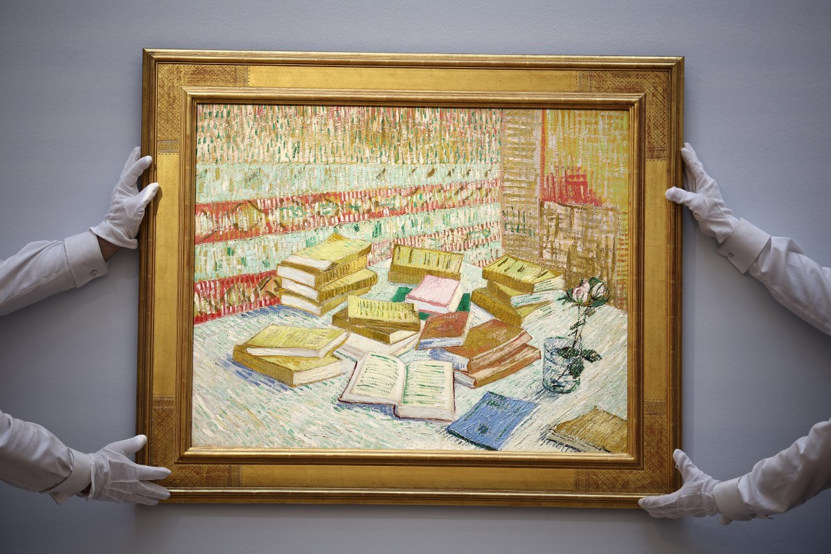 خبراء يثبّتان لوحة زيتية داخل إطار ذهبي فاخر