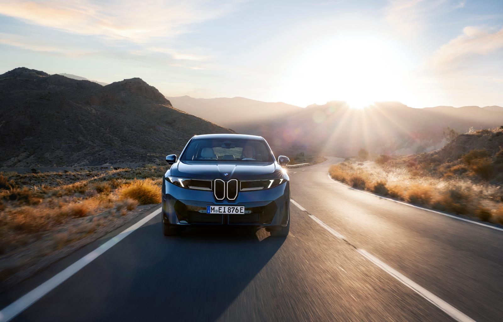 BMW iX3 تنطلق في طريقها بهدوء بينما تلتقط العدسة تضاد الضوء مع الخطوط الحادة في الواجهة